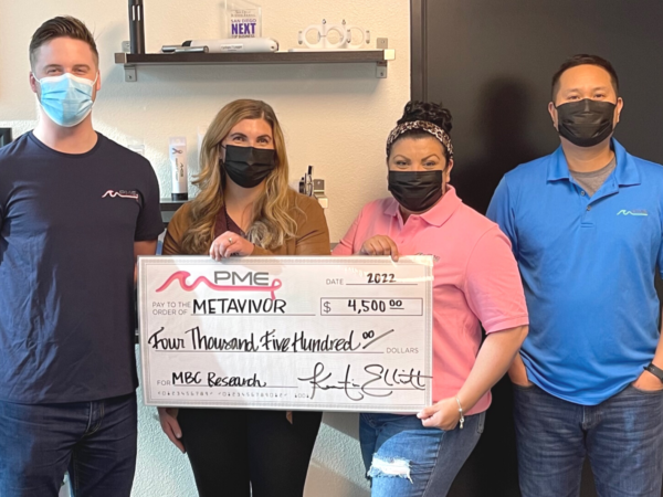The PME leadership team holding a check with a $4,500 donation to METAvivor