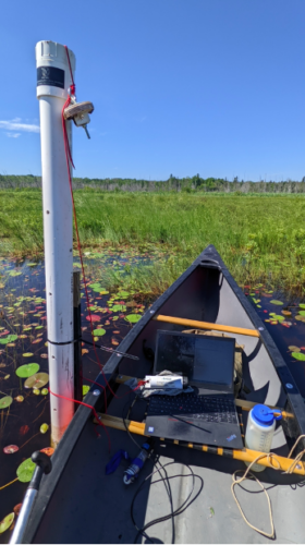 An image of a boat in the Great Lakes' coastal wetlands with the miniDOT® logger on display.