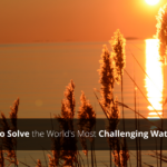 An orange sunset over the water with a text overlay that reads, "Partnering to Solve the Worlds Most Challenging Water Problems."