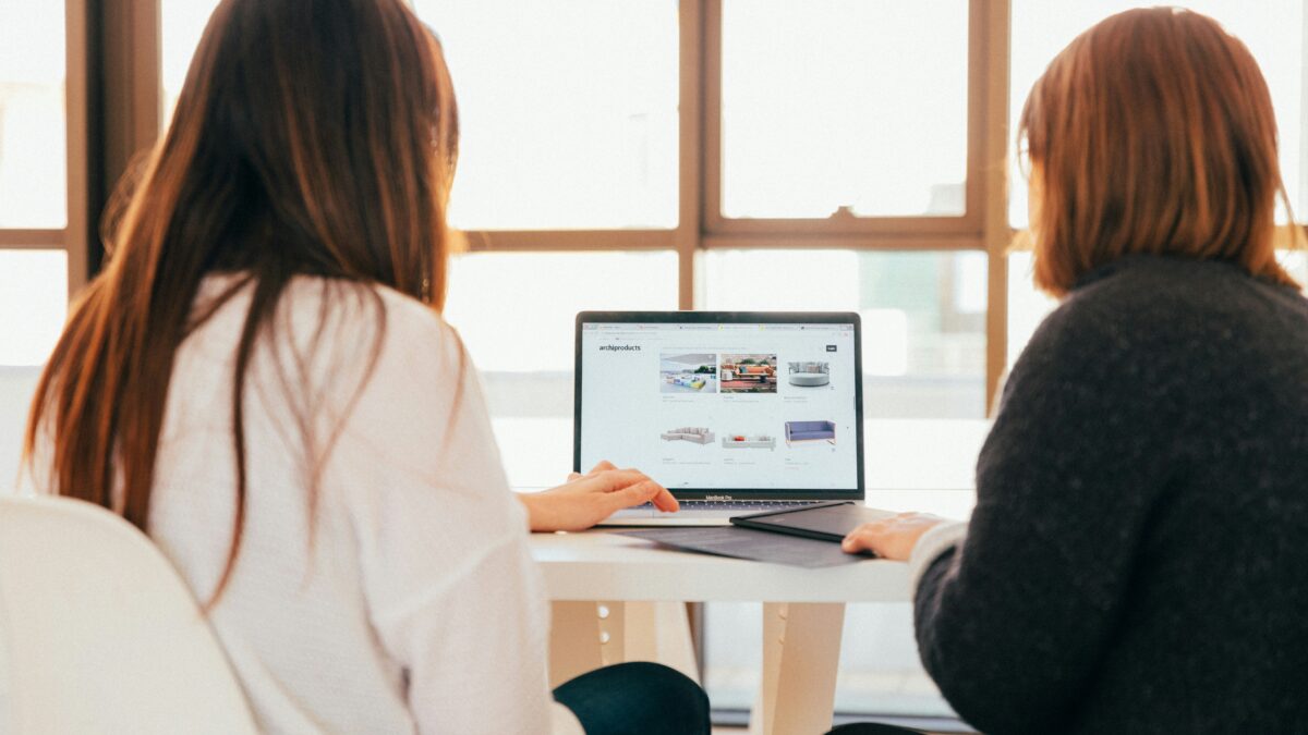 Graphic of two women working in front of desktop