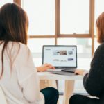 Graphic of two women working in front of desktop