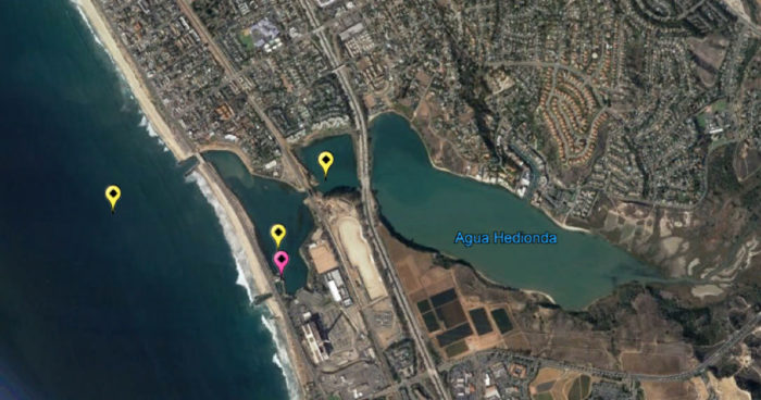 Graphic displaying three different locations in yellow (mooring currently in the Pacific Ocean right outside of the lagoon, one in the outer lagoon closest to the ocean near the Aquafarm and one in the middle of the lagoon) as well as the shore-based system in pink.