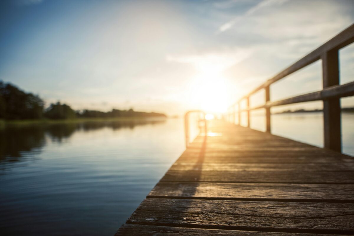 Graphic of sunlight shining on lake with wooden deck