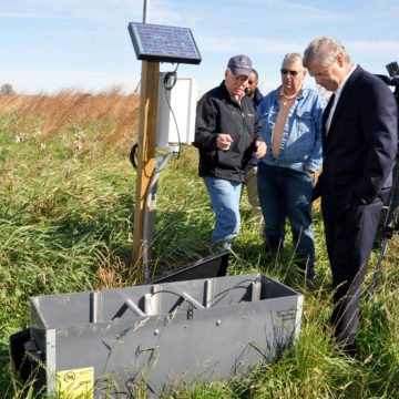 An image captured of Iowa farmer Nick Meier speaking to Agriculture Secretary Tom Vilsack, right, and La Porte City mayor David Neil about the saturated buffer conservation practice near a local stream on Meier’s farm in La Porte City, IA.