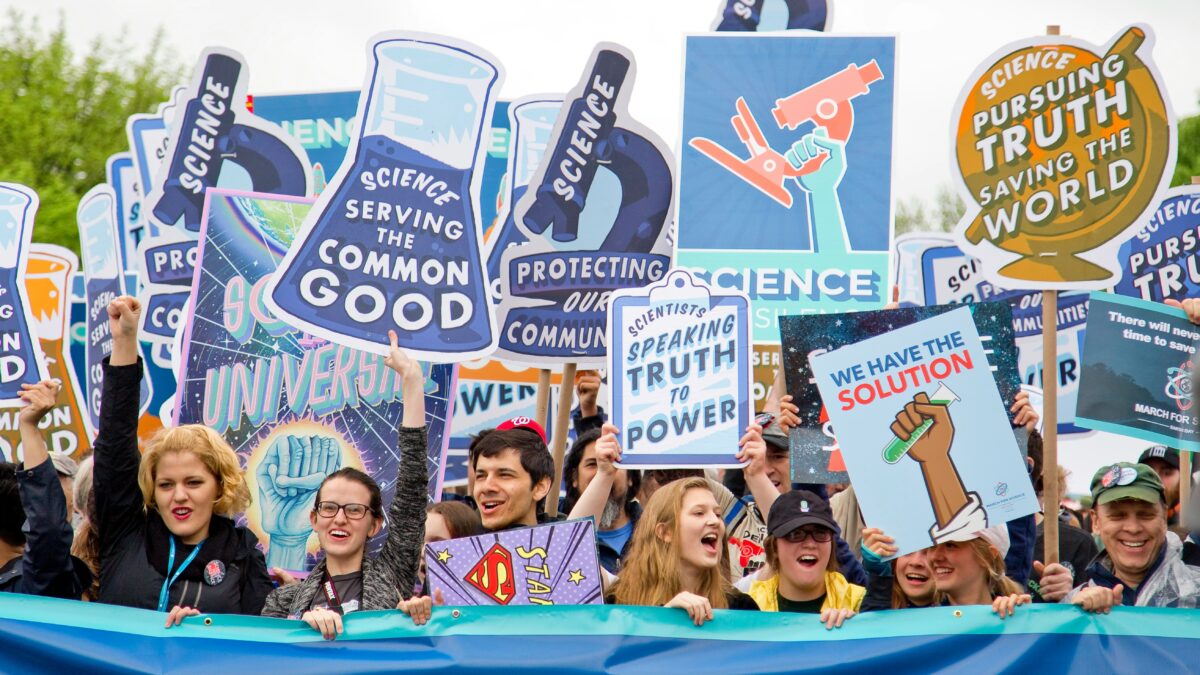 A graphic of the science community during an event displaying signs and posters.